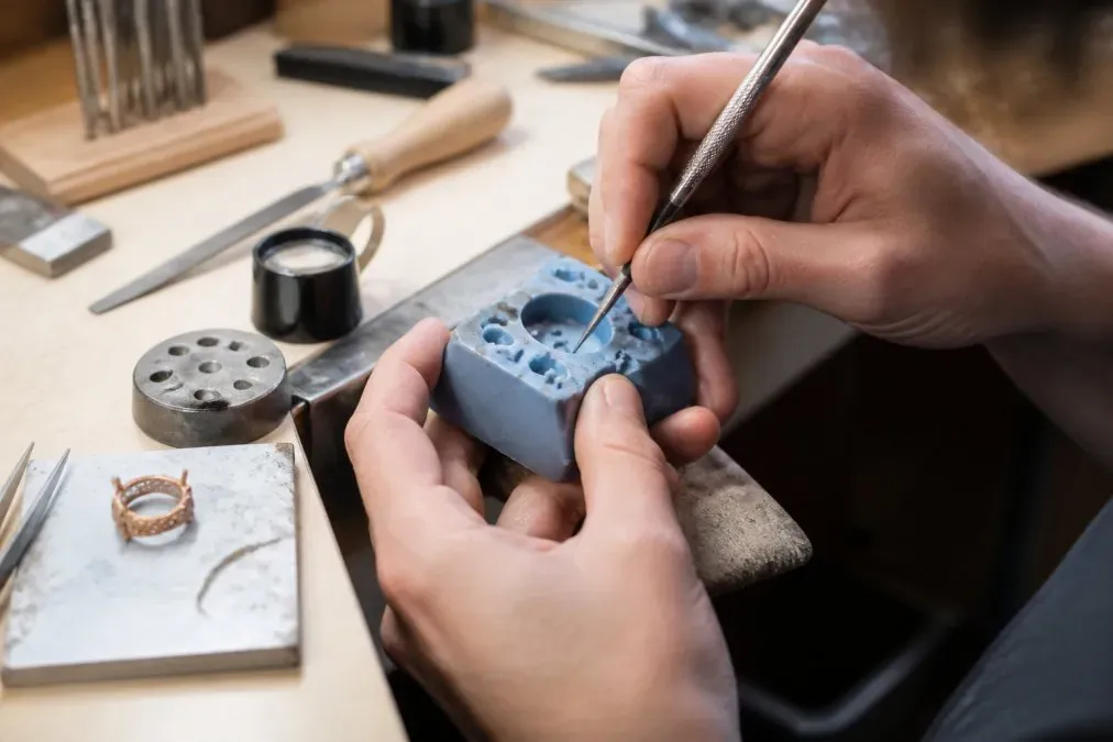 Un bijoutier travaille un moule en silicone pour la fabrication petite série de bijoux artisanaux dans son atelier.